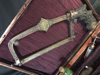 Overhead detail of the bone saw resting in the padded burgundy case interior.