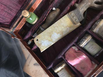 Close-up of the weathered cleaver blade and aged label detailing inside the case.