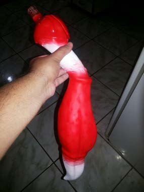 A painted red limb section held in hand during the paint stage.