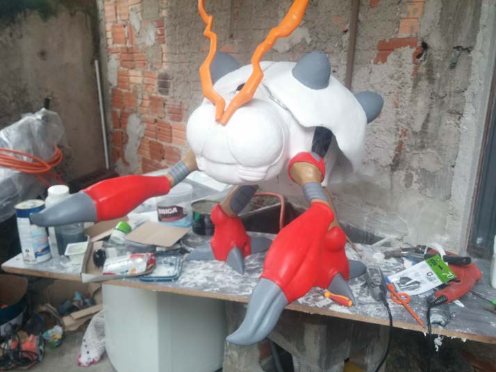The full build in primer beside painted red components in the workshop.